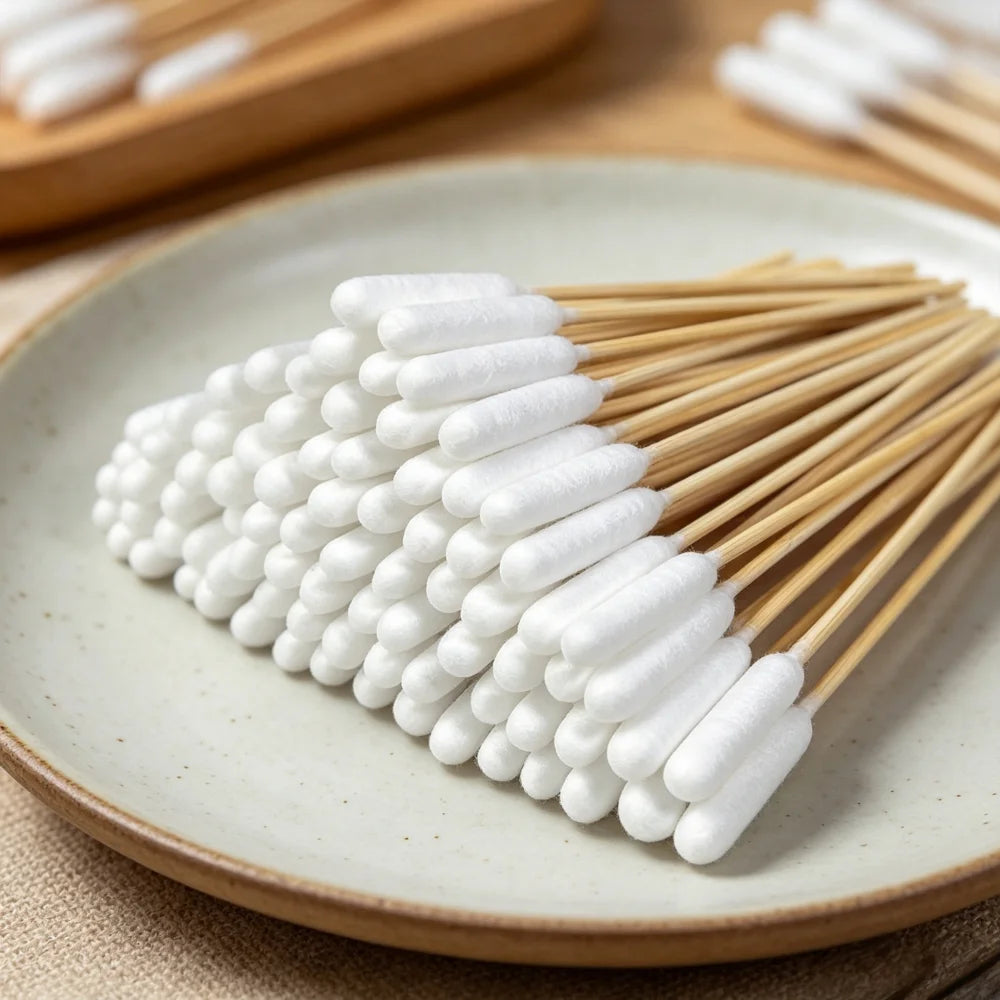A pile of white cotton swabs arranged on a light ceramic plate.