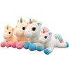 A group of five soft, white unicorn plush toys with pastel colored manes and hooves.