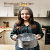 A young girl holds a stainless steel pet water fountain on a kitchen counter.