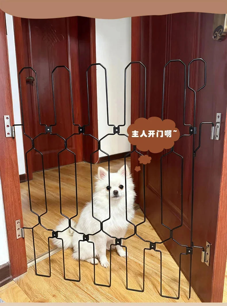 A black metal pet safety gate is installed on a wooden door, featuring a decorative scroll design.
