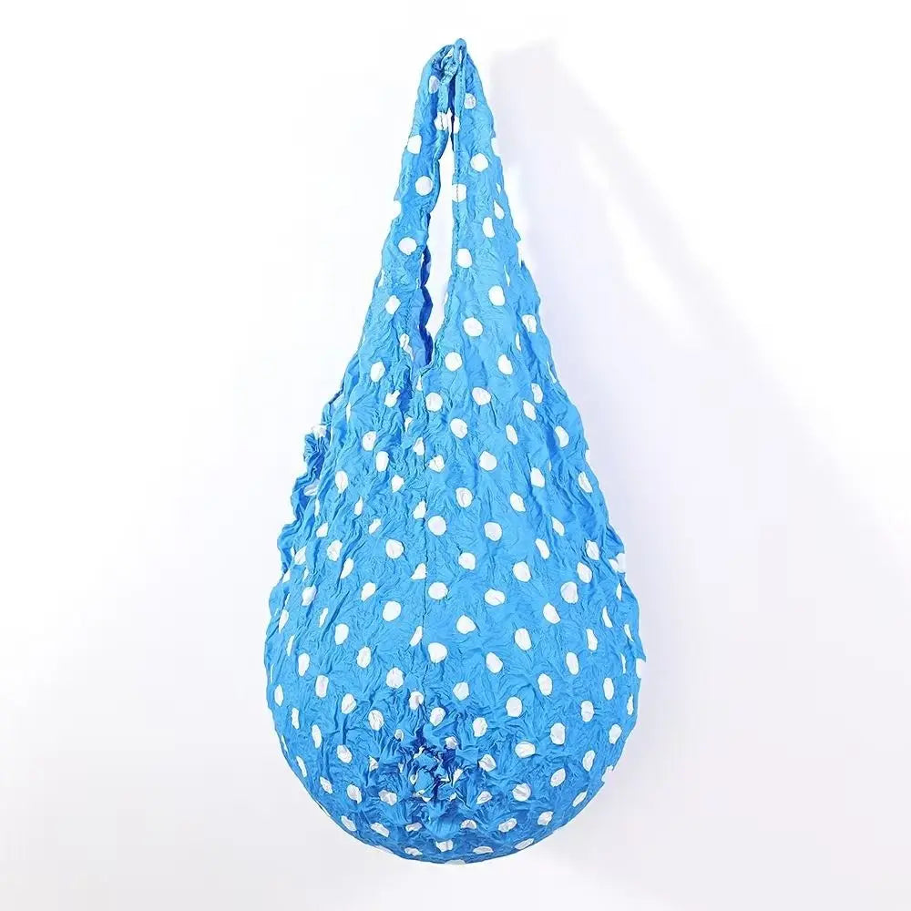 A bright blue reusable foldable bubble shopping bag with white polka dots.