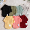 A collection of knitted winter sweaters for dogs and cats in various shades of green, pink, and red.