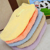 Una pila de suéteres de invierno para perros suaves y cálidos en varios colores pastel, incluyendo amarillo, naranja, azul y 