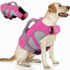 A light-colored dog wearing a bright pink and gray adjustable life jacket for swimming safety.