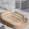 A round woven sisal board with concentric lines and small textured pieces is shown on a light surface.