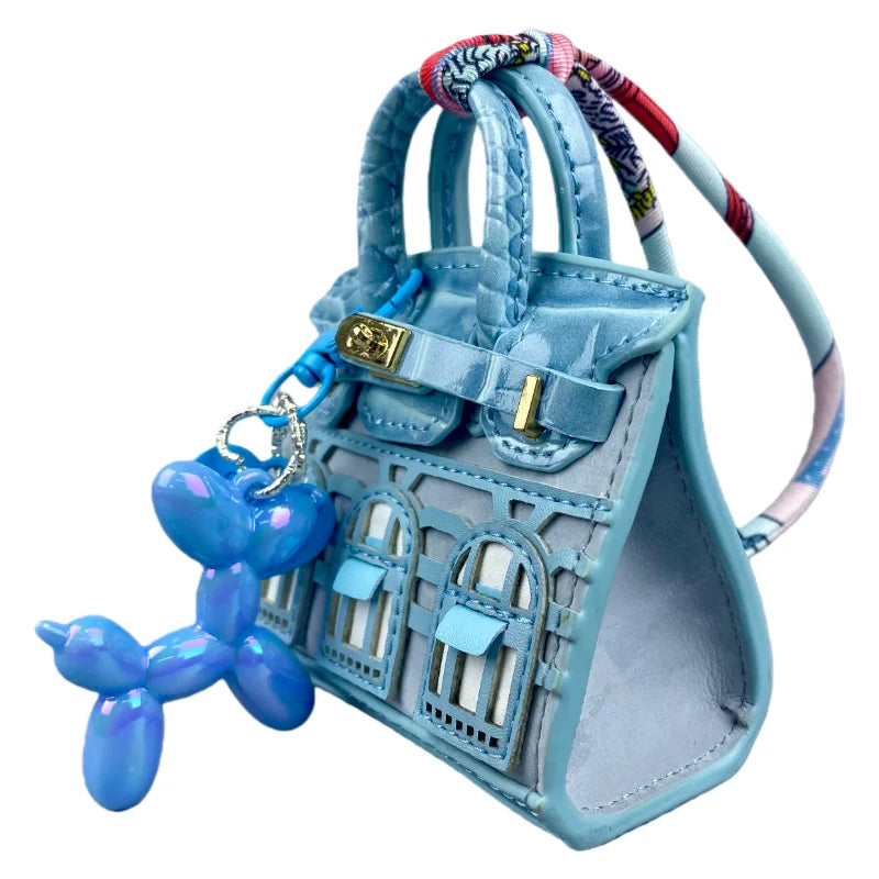 Light blue handcrafted mini house-shaped bag with a puppy keychain charm and colorful patterned strap