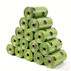 A stack of fifteen rolls of heavy duty dog poop bags in a light green color.