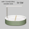 A white automatic bird bathtub with a resting stick and a green base.