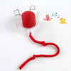 A red training ball with a silicone cover and a red string attached, used for automatic cat and dog training.