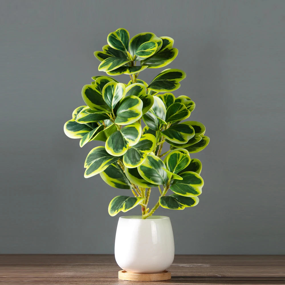 Künstliche Herzblatt-Ficus-Pflanze mit grün-gelblichen variegierten Blättern in einem weißen Topf