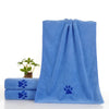 Une pile de serviettes pour animaux en microfibre bleues avec des motifs de pattes.