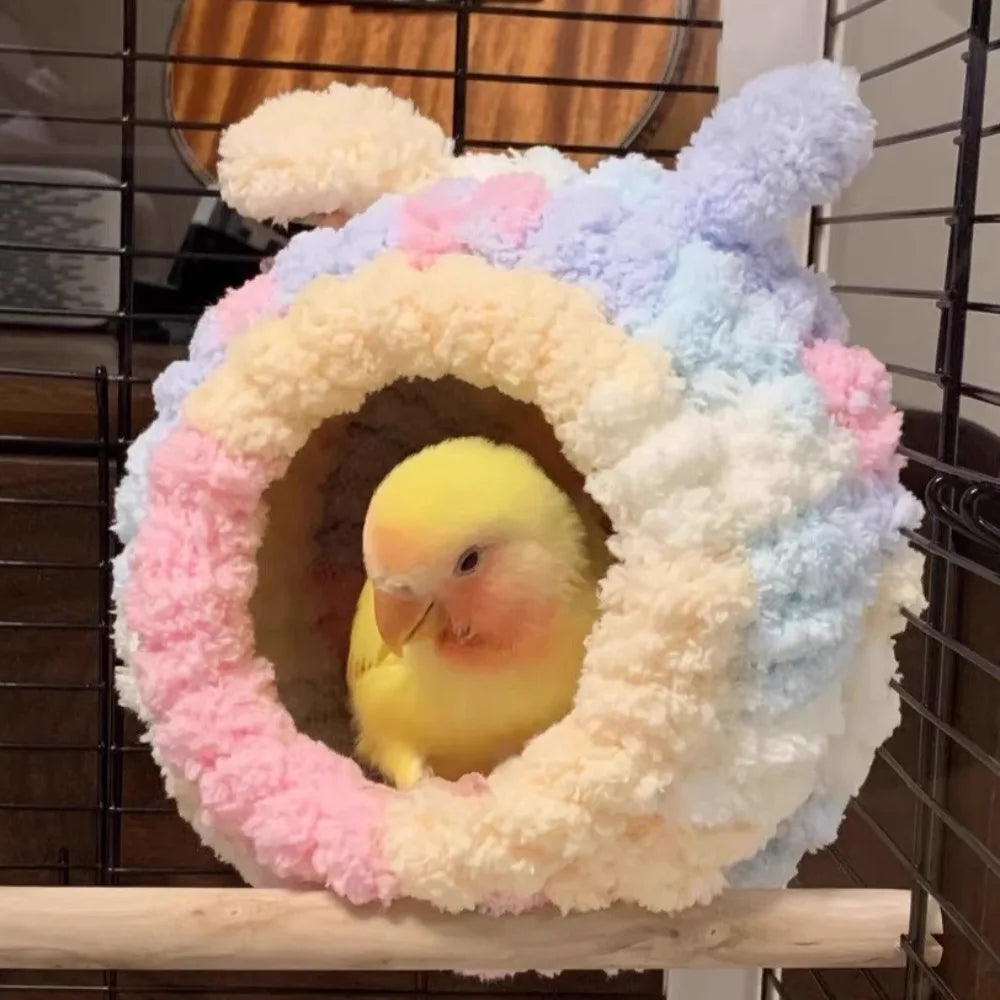 Flauschiges, farbenfrohes Flanell-Vogelnest mit einem gelben Küken darin, auf einer Holzoberfläche präsentiert.