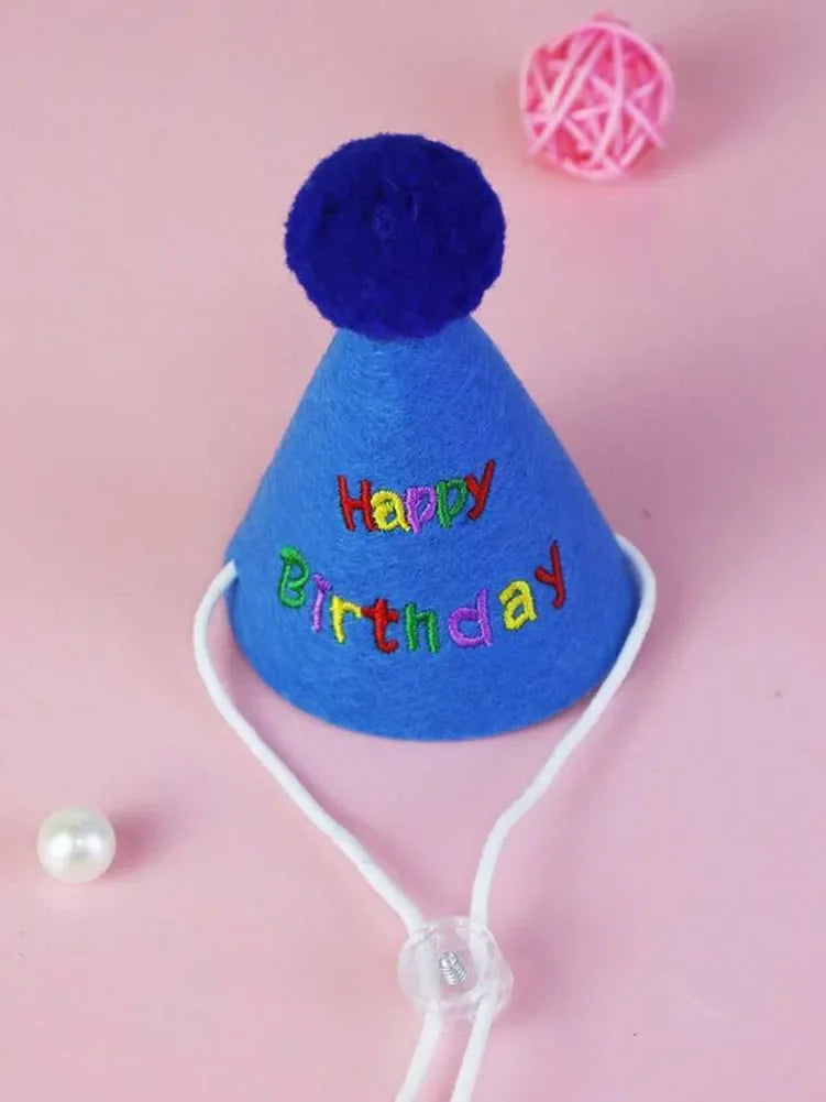 Un bibou de fête bleu vif en feutre avec un chapeau de fête violet et un pompon rose, fixé à un élastique blanc.