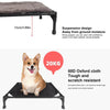 A brown dog is sitting on a black portable elevated cot with a removable shade canopy.