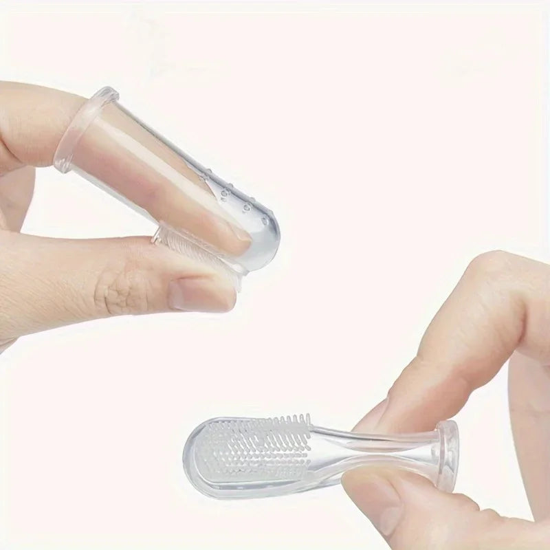A hand holds a clear silicone pet toothbrush, showing the bristles and handle.