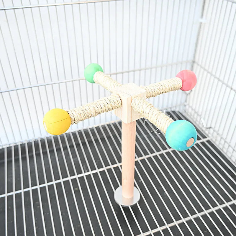 Papagei-Spielzeug mit Holz-Drehstand und bunten Kugeln an den Armen.