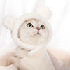 Flauschiger weißer Kater mit gestricktem Hut und großen Ohren, der nach oben schaut.