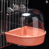 A clear plastic hanging bird bath for parakeets is shown in a wire cage.