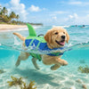 A golden retriever wearing a bright green and blue high visibility dog life vest swims in clear ocean water.