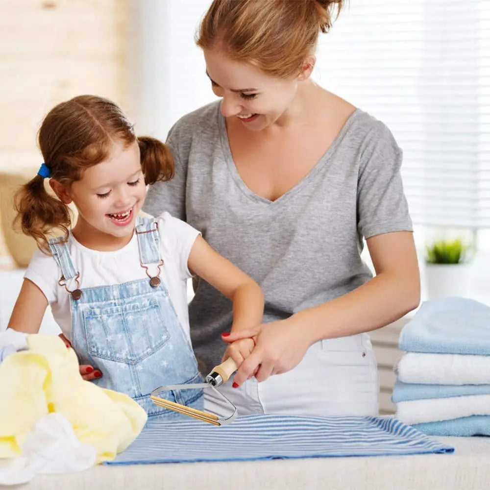 Eine Frau demonstriert ein manuelles Fasenentferner für Kleidung an einem Kinderkleid.