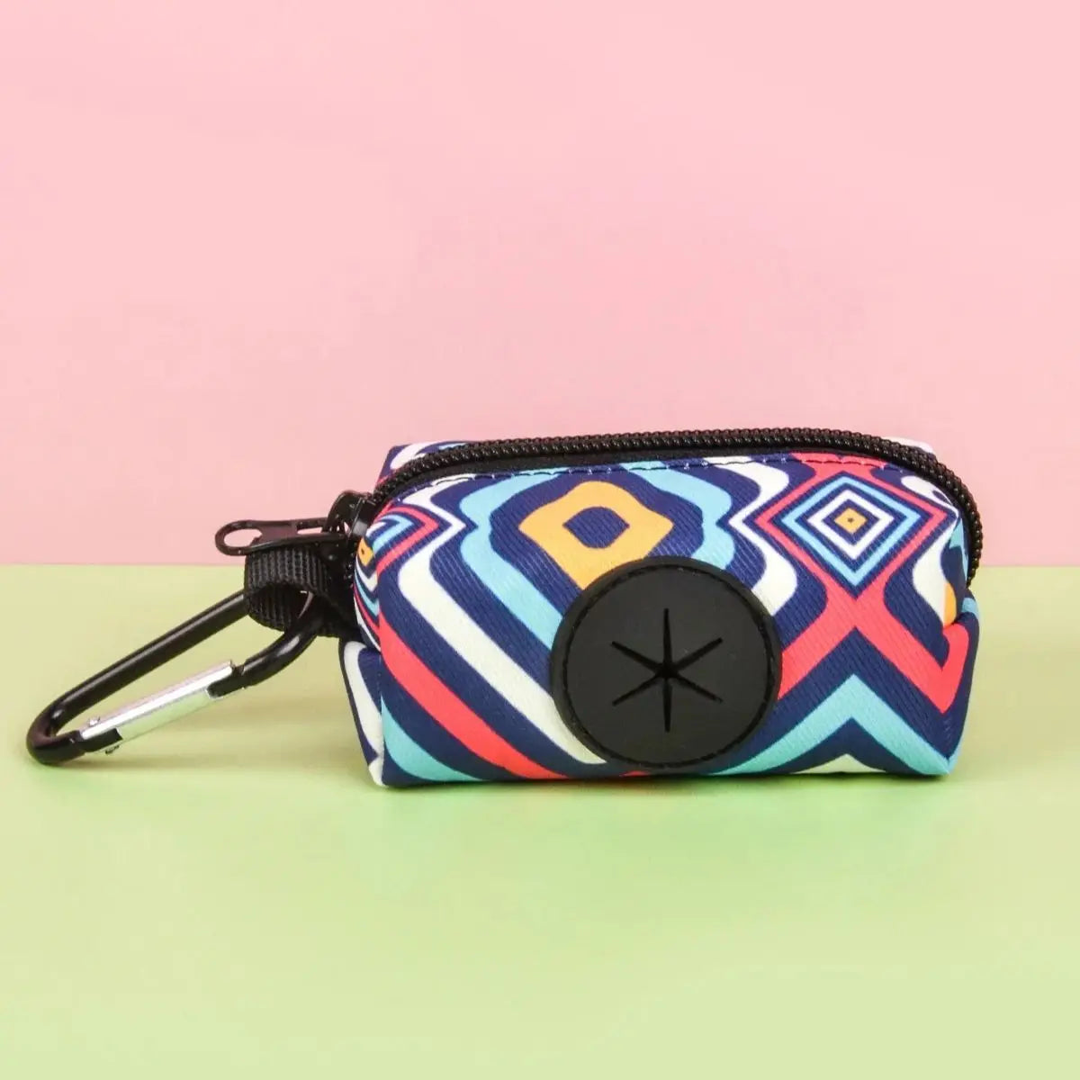 A colorful patterned pouch designed to hold dog waste, featuring a black clip and a circular opening.