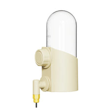 A beige reusable birds water feeder with a clear dome and a yellow tube for feeding.
