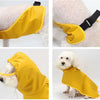 A bright yellow waterproof pet raincoat being worn by a white dog.