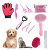 Sammlung von rosa und schwarzen Tierpflegewerkzeugen, darunter Nagelschere, Bürste und rosa Gummi-Pfotenhandschuhe.