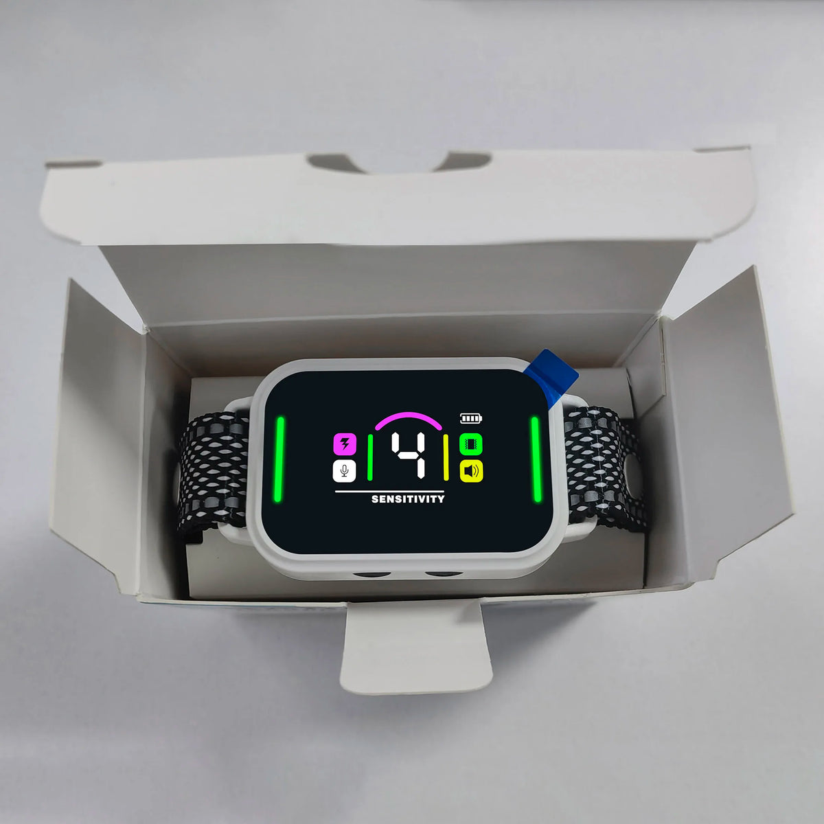 A white dog bark collar is displayed inside its packaging box.