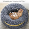 A fluffy gray pet bed with a yellow trim, featuring a small orange kitten resting inside.