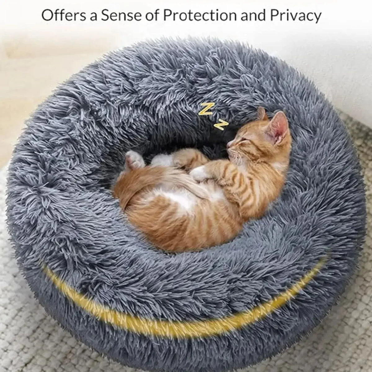 A fluffy gray pet bed with a yellow trim, featuring a small orange kitten resting inside.