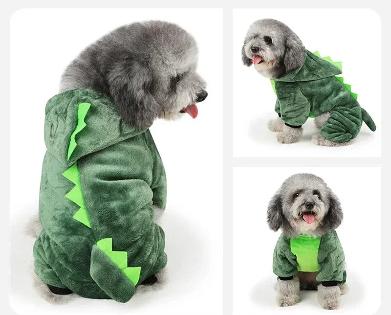 Un perro gris esponjoso vistiendo un mono de dibujos animados verde para mascotas pequeñas.