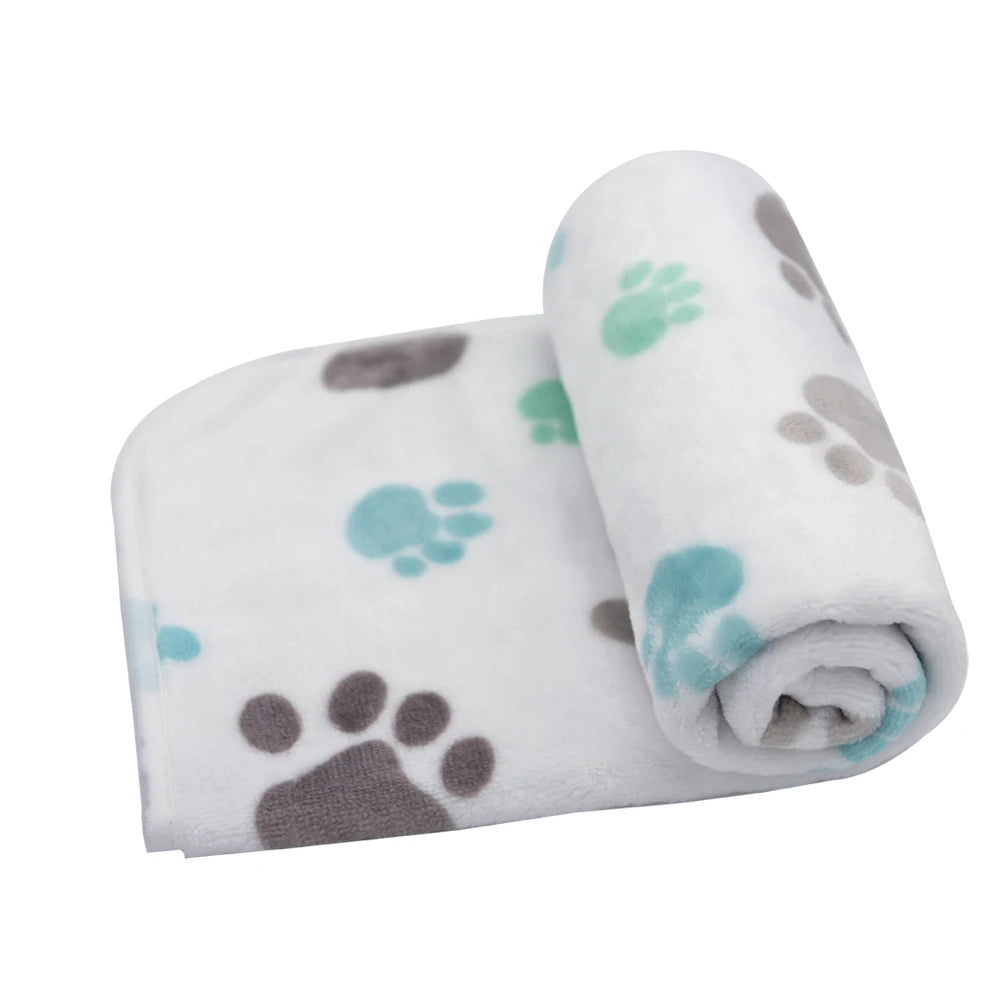 Rolled white pet blanket with gray and teal paw prints