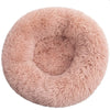 A round, fluffy, light pink pet bed for dogs and cats.