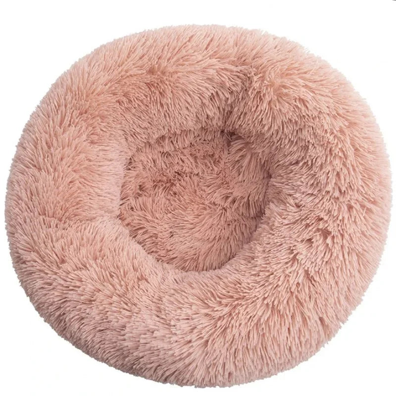 A round, fluffy, light pink pet bed for dogs and cats.