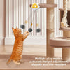An orange tabby cat plays with a self-moving interactive toy ball suspended from a wooden post.