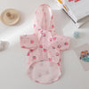 Pink cartoon printed dog raincoat for small breeds displayed on a white surface.