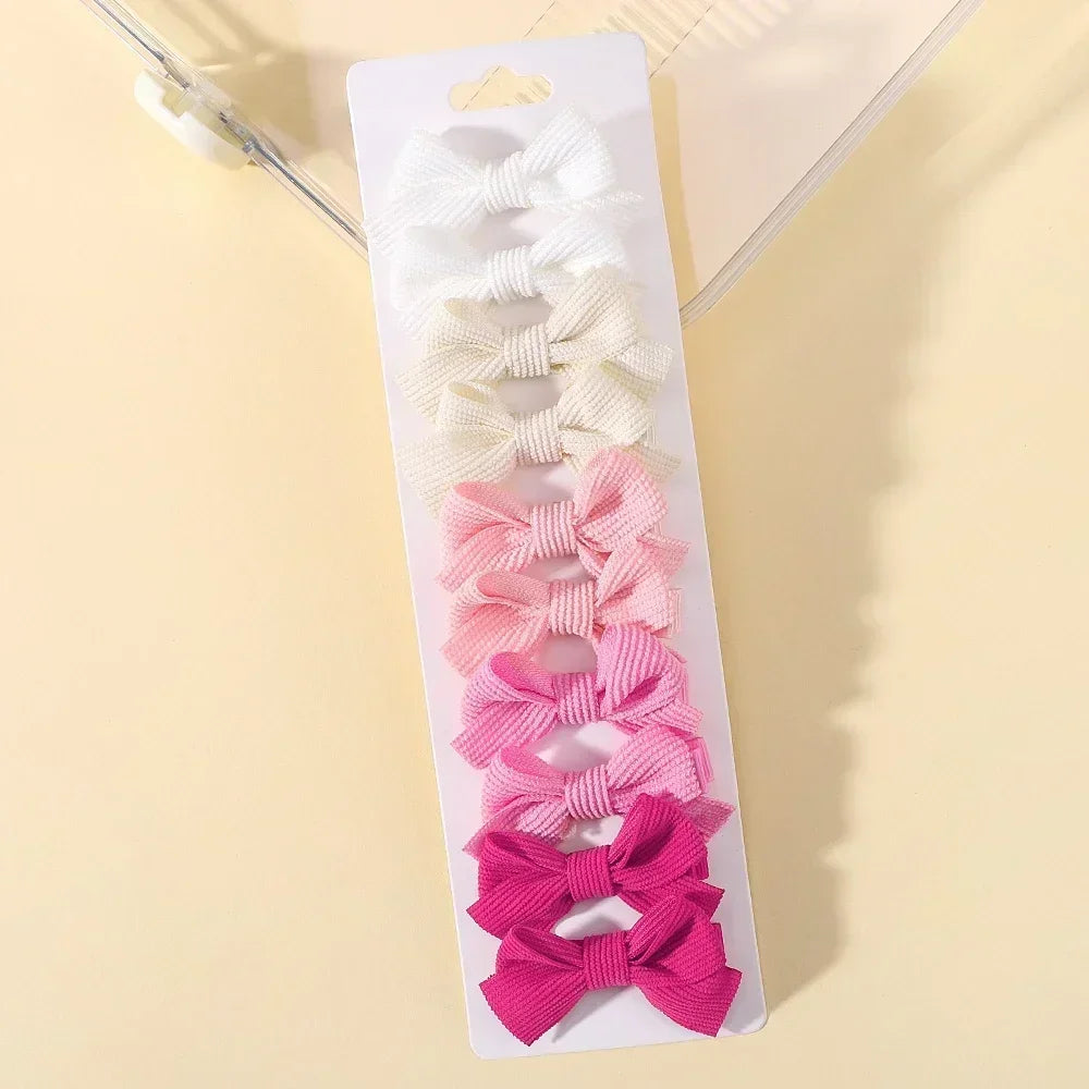 Présentation de barrettes à cheveux en ruban colorées pour filles, arrangées dans une boîte blanche.
