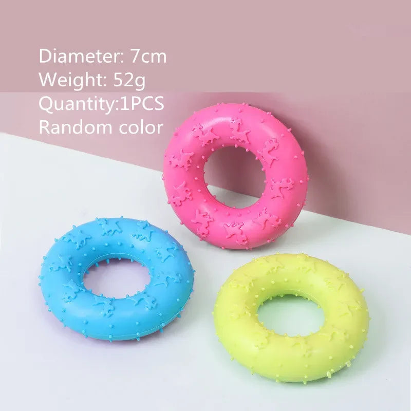 Three pink, blue, and yellow rubber chew toys for small dogs shown on a white surface.