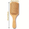 A wooden bamboo hair brush with massage bristles shown vertically.