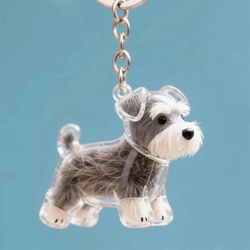 Figurine en résine d'un petit chien duveteux gris et blanc suspendu à une chaîne argentée.