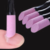 A hand holds a professional nail file and cuticle remover tool with pink glitter-infused acrylic tips.