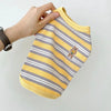 A yellow and gray striped stretchy pet tank top for cats and small dogs being held by a hand.