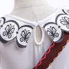 Weißes Kleid mit Blumenkragen, schwarz-grauen Mustern und einem braunen Akzentstreifen.