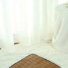 A fluffy white pet tent is visible on a light-colored rug with a brown mat.
