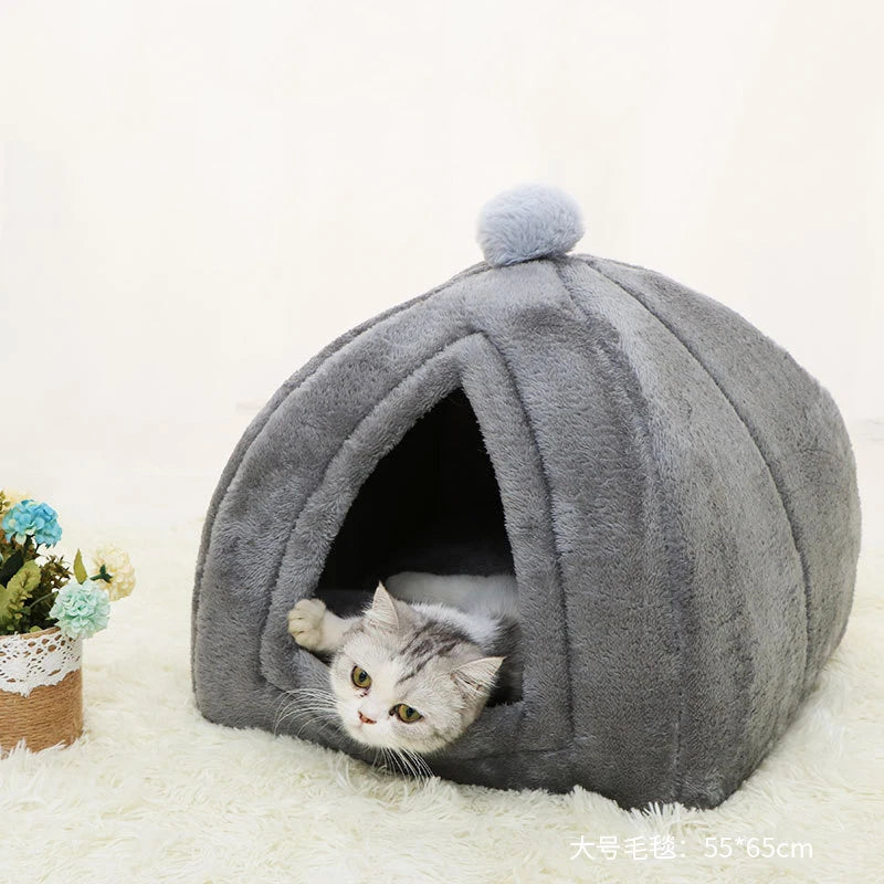 A gray cat bed shaped like a cave with a fluffy gray cushion inside.