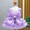 A lavender satin pet dress with a large bow and D-ring displayed on a mannequin.