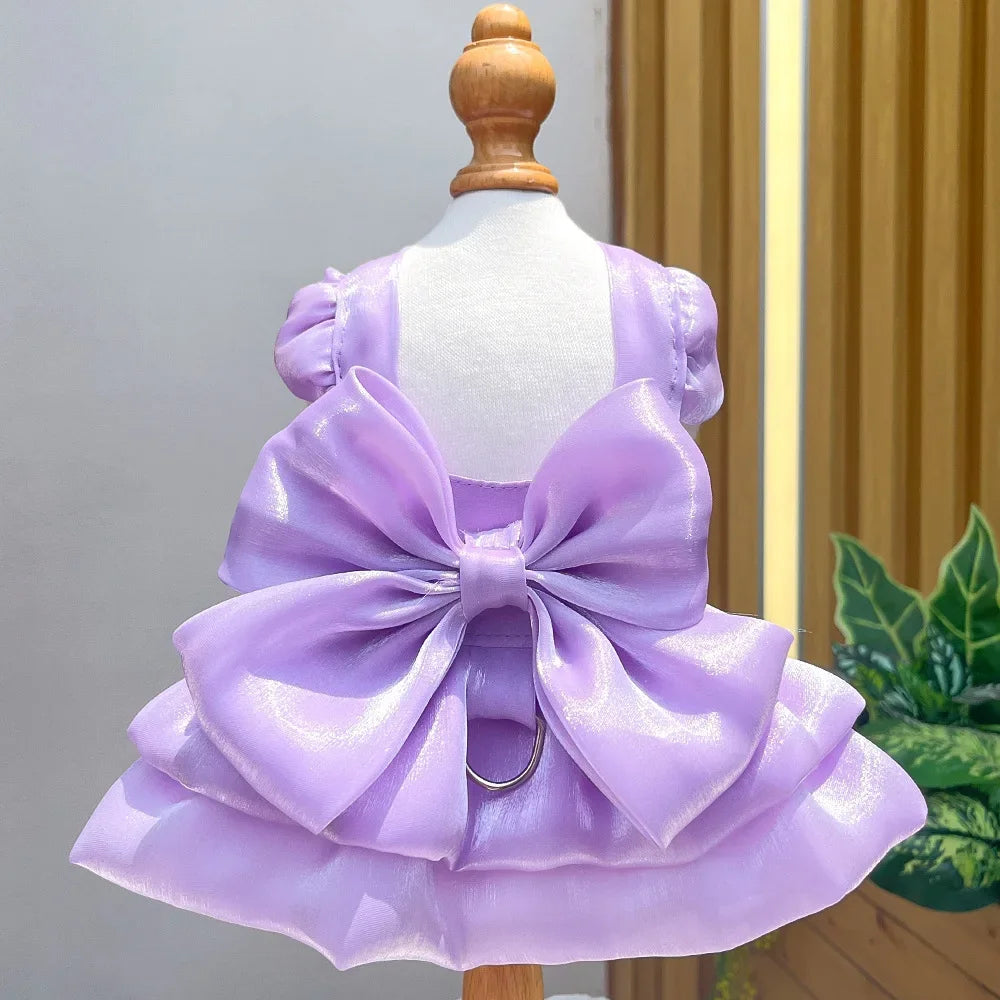 A lavender satin pet dress with a large bow and D-ring displayed on a mannequin.