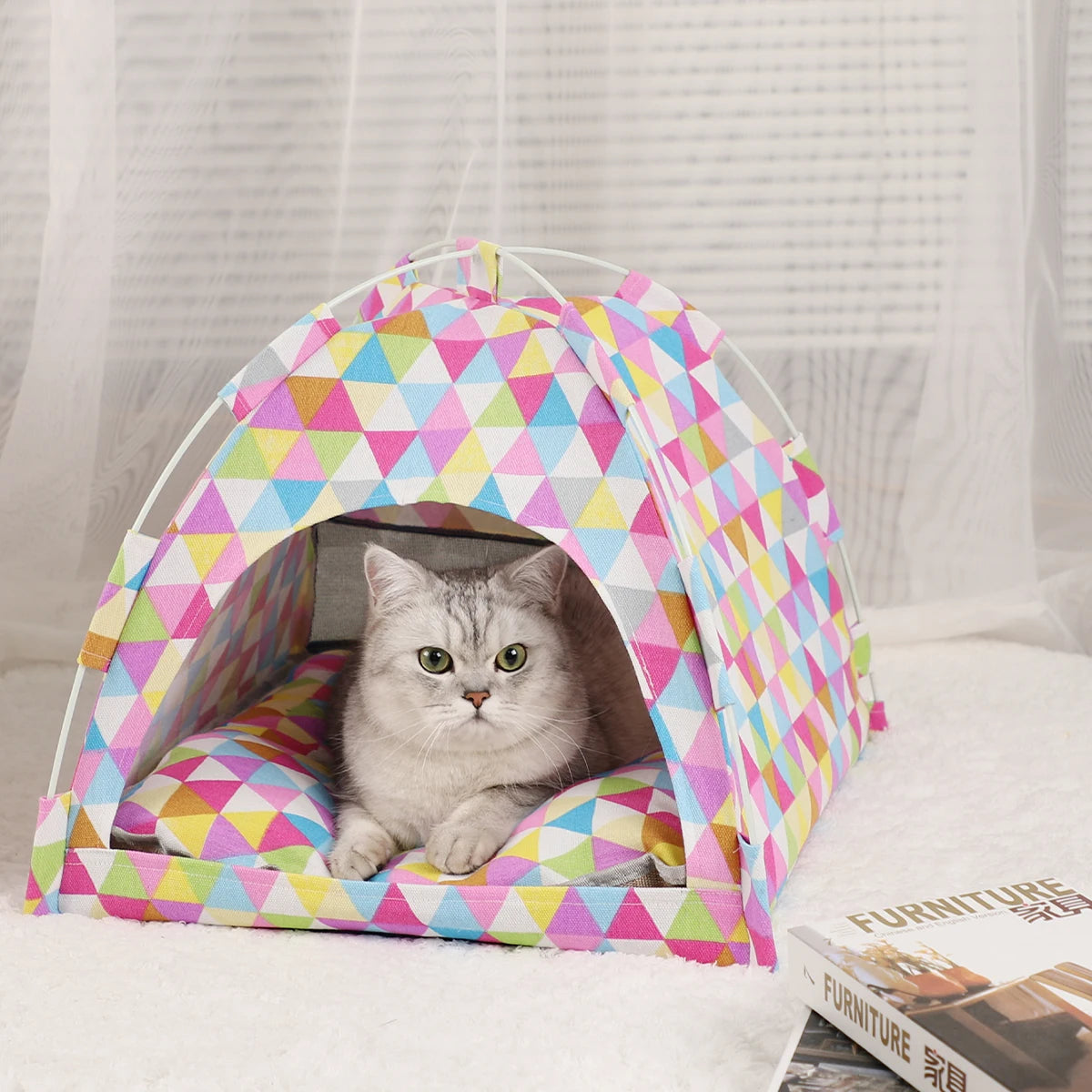 A cozy pet tent bed for cats made of colorful fabric, resting on a white surface.
