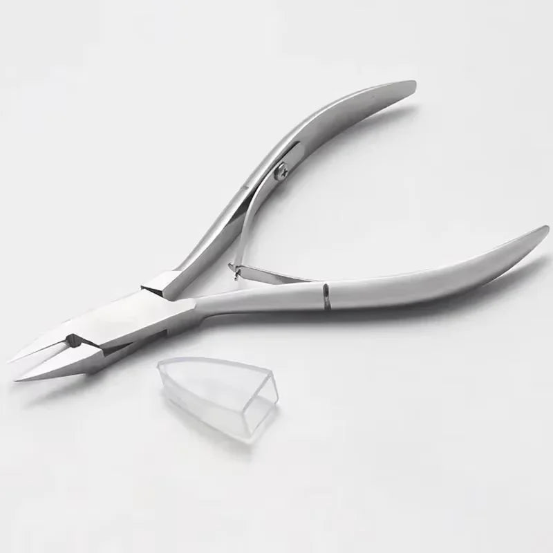 A pair of silver precision stainless steel cuticle nippers for nail care lying on a white surface.